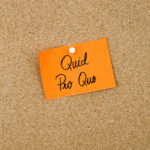 QUID PRO QUO written on orange sticky note