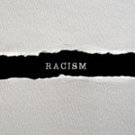 Racism written on torn paper