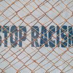 Fence that has stop racism sign