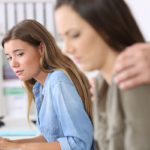 boss touching female employee on shoulders