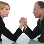 Businessman and woman arm wrestling