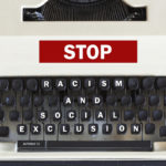 Retro typewriter with message stop racism and social exclusion message written on it