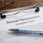 Sexual Harassment Complaint Form With Pen and glasses on desk