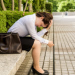 depressed business woman sitting on the bench after being fired