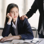 Asian women sexual harassment at working in the office Manager putting his hand on the shoulder of his