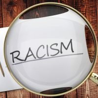 Study, learn and explore racism - pictured as a magnifying glass enlarging word racism, symbolizes analyzing, inspecting and researching the meaning of racism, 3d illustration