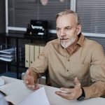 Bearded mature man speaking to recruiter during job interview