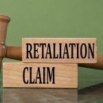 RETALIATION CLAIM - words on wooden blocks with a judge's gavel in the background