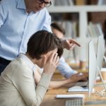 Stressed female employee suffering from discrimination of angry male boss