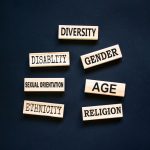 Diversity symbol. Diversity ethnicity gender age sexual orientation religion disability words written on wooden block. Beautiful black background. Equality and diversity concept. Copy space.